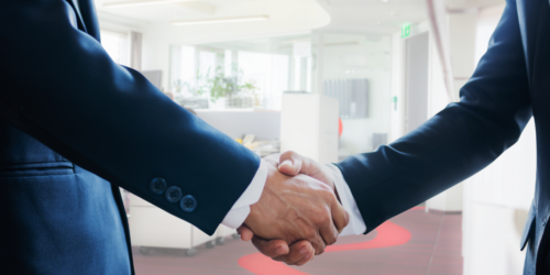 Handshake in a professional office with red accents